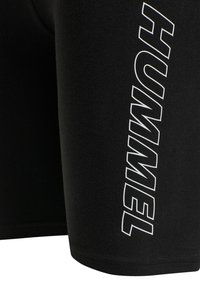 Svarta träningsshorts tillverkade av elastiskt tyg, med en framträdande vit "HUMMEL"-logotyp tryckt vertikalt längs sidan.