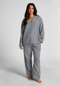 Zwart-wit geruite pyjamaset met een knoopsluiting aan de bovenkant en broek met elastische taille, gemaakt van zachte stof en met lange mouwen.