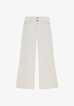 Jeans blancs à jambe large avec un pli sur le devant, fermeture par bouton et glissière, poches avant et arrière, marqués Guess Jeans.