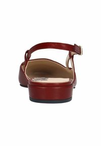 Rode leren sandalen met een dunne enkelband en een lage hak, met een gladde textuur en een rond te ontwerp.