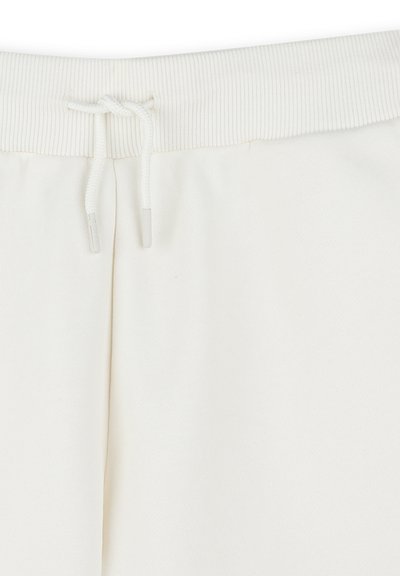 Pantalon de survêtement blanc avec une taille côtelée et un cordon de serrage, fabriqué en tissu doux en mélange de coton, avec une texture lisse et une coupe ajustée.
