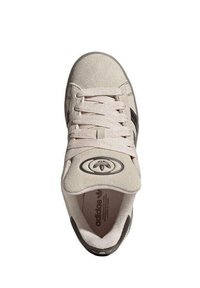 Baskets en suède beige avec accents rayés noirs plats et lacets. Bout arrondi, languette rembourrée avec logo et doublure intérieure en tissu doux.