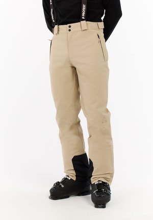 Beige sneeuwbroek met zwarte accenten, met een rechte pijpontwerp, ritszakken en een verstelbare tailleband met ophangbanden.
