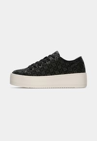 Sneaker neri con motivo, suola bianca piatta, tessuto superiore testurizzato, chiusura con lacci e accenti lisci sul tallone e sui lati.