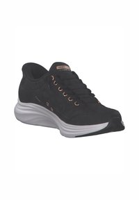 Schwarzer Sportschuh mit gesteppter Oberseite, metallischen Ösen und einer weißen, gepolsterten Zwischensohle. Verfügt über eine strukturierte Rückseite und eine markierte Zunge.