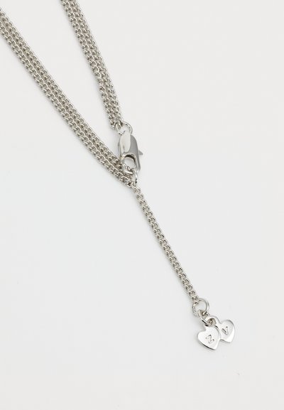 Un colier din silver, cu două pandantive în formă de inimă gravate cu literele "Z" și "V". Lanțul are un închizător tip lobster pentru o prindere sigură.