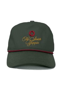 Groene pet met een ronde vorm, voorzien van een rood kruis-embleem en goud geborduurde tekst "De Zwitserse Yuppie" met een bordeauxrand langs de rand.