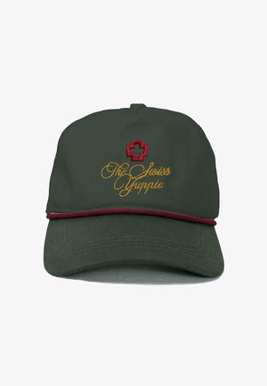 Groene pet met een ronde vorm, voorzien van een rood kruis-embleem en goud geborduurde tekst "De Zwitserse Yuppie" met een bordeauxrand langs de rand.