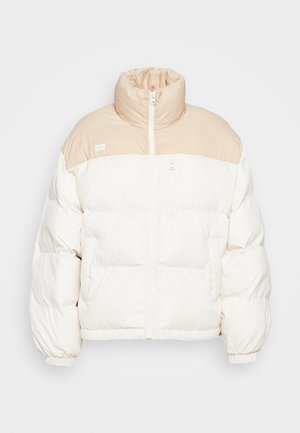 Chaqueta de plumas con un cuello alto, que presenta una combinación de colores en crema y beige claro. Fabricada con tejido suave, cuenta con acolchado horizontal y un zipper frontal.