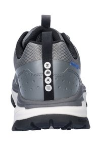 Grijze sportieve schoen met een gestructureerde mesh bovenkant, zwarte accenten, bevestigingslus en iconen voor buitenactiviteiten op de achterkant. Rubberen zool voor grip.