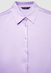 Light purple button-up shirt with a pointed collar and visible buttons down the front, labeled size small.