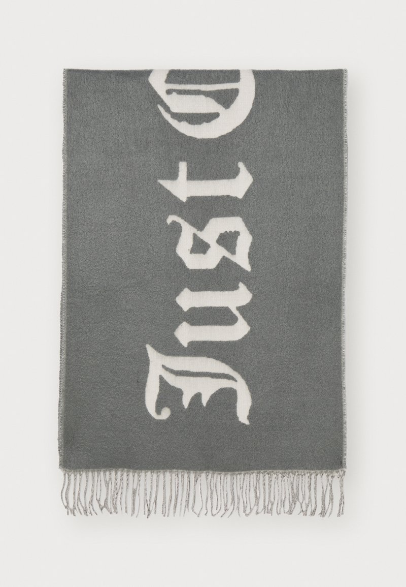 Grå strikket plaid med hvid gotisk stil tekst. Kanterne er afsluttet med frynse-detaljer. Blød tekstur med et alsidigt design.
