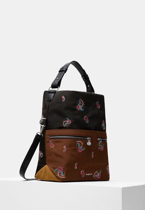 Schwarze und braune Schultertasche mit buntem Paisley-Stickmuster, vordere Reißverschlusstasche und verstellbarem schwarzen Riemen, platziert auf einem weißen Podest.
