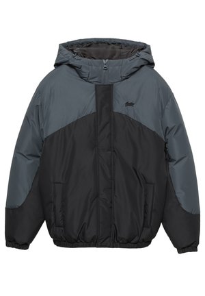 Jaka s umetnutim sivim i crnim panelima, s kapuljačom, prednjim patentnim zatvaračem, elastičnim manšetama i dva bočna džepa. Glatki, vodootporni materijal.