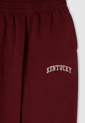 Pantaloni della tuta color bordeaux con cintura elastica, caratterizzati da testo ricamato bianco con la scritta "KENTUCKY" in un design ad arco. Tessuto morbido e testurizzato.