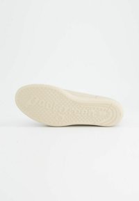 Světlobéžová podrážka boty s texturovaným gripem, s kruhovým vzorem a vyraženým názvem značky "paul green," mírně vyvýšeným směrem k okrajům.