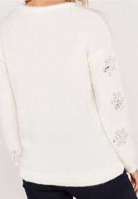 White, fluffy sweater with a round neckline and long sleeves. Features silver snowflake embellishments and ribbed hem. Soft texture.