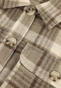 Wollen geruite shirt in beige en bruin, met een klassieke kraag, twee borstzakken en lichtgekleurde knopen. Zachte textuur en warm ontwerp.