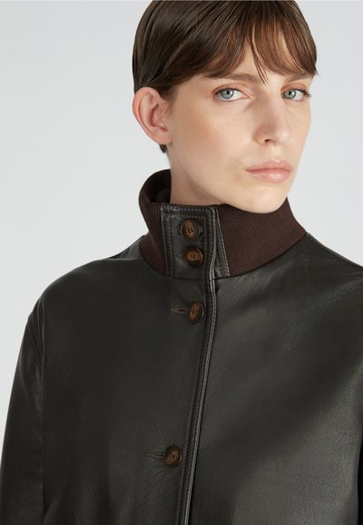 Dunkelbraune Lederjacke mit hohem Kragen, ausgestattet mit vier braunen Knöpfen und einem strukturierten Innenfutter für zusätzlichen Wärme.