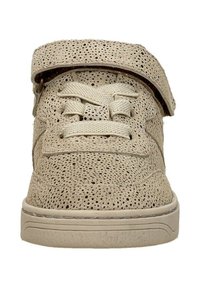 Beige geperforeerde sneaker met een textuur oppervlak, voorzien van platte veters en een enkele klittenbandsluiting bovenaan voor eenvoudig vastmaken.