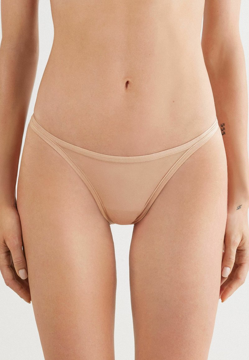 Nude mesh bikini slip met dunne elastieken, een low-rise snit en een gladde stofstructuur, die een minimalistisch en comfortabel ontwerp biedt.
