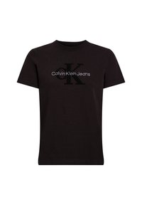 Camiseta de algodón negra con cuello redondo. Presenta una gran "K" bordada y el texto "Calvin Klein Jeans" en blanco encima. Diseño sencillo.
