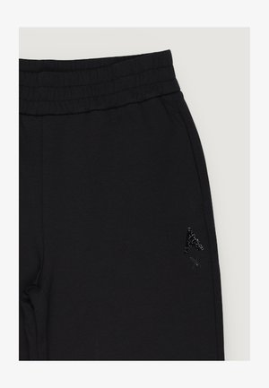 Černé kalhoty s elastickým pasem, bočními kapsami a texturovaným černým logem "A" a "X" na pravém stehně.