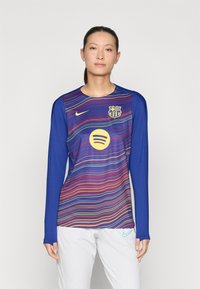 Sinine pika varrukaga jalgpallipusa, millel on mitmevärvilised horisontaalsed triibud, esitades FC Barcelona vappi ja ümmarguse Spotify logo esiküljel.