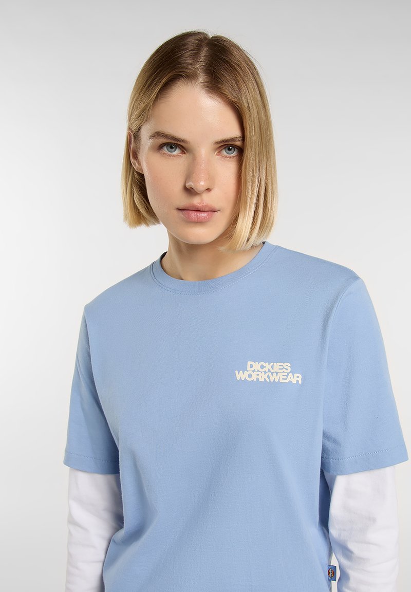 Light blue cotton t-shirt with short sleeves, featuring a white embroidered logo "DICKIES WORKWEAR" on the left chest.