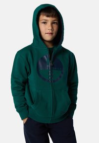 Felpa verde con zip, caratterizzata da un grande logo blu navy sul petto, tasche frontali e una consistenza morbida. Include un cappuccio e polsini a coste.