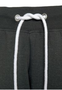 Donkergrijze sweatpants met een geribbelde tailleband, voorzien van een witte trekkoord dat door zilveren oogjes is geregen.