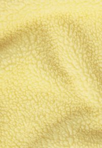 Keltainen fleece-kangas, jossa on pehmeä, teksturoitu pinta, tiheä, pörröinen pinta ja tasainen väritys koko alueella.