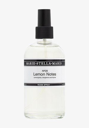Helder glazen kamersprayfles met een zwarte spraydop. Het etiket bevat zwart-witte tekst met de vermelding "Citrusnoten" en een lijst van geurige ingrediënten.