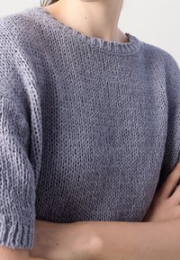 Helle lila gestrickter Pullover mit kurzen Ärmeln, der ein strukturiertes Maschenmuster und einen runden Halsausschnitt präsentiert.