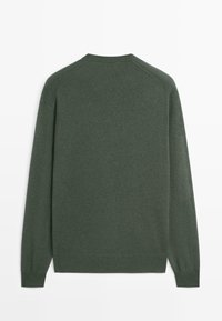 Grön stickad tröja med rund halsringning och långa raglanärmar. Mjuk textur med ribbstickade muddar och fåll. Enkel design.