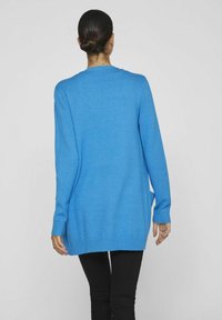 Blauer gestrickter Cardigan mit langen Ärmeln, gerippten Bündchen und geradem Saum, der eine lockere Passform und eine sanfte Textur aufweist.