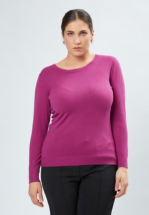 Maglione magenta a maniche lunghe in morbido tessuto a maglia con scollo rotondo e orlo a coste. Abbinato a pantaloni scuri per un contrasto.