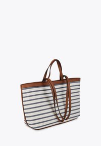 Randig tote-väska med en texturerad canvas-yta, med marinblå och vita ränder, bruna konstläderhandtag och en rymlig design.