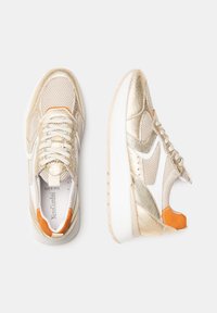Baskets or en or crème avec une tige texturée, des panneaux en maille et des accents orange. Présentent un logo Swoosh blanc et une semelle blanche épaisse.