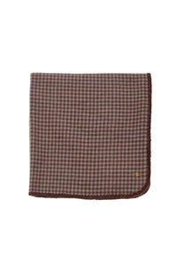 Brun og lyseblå ternet tæppe med en blød tekstur, afsluttet med en mørkebrun kant og en lille gylden logoaccent.