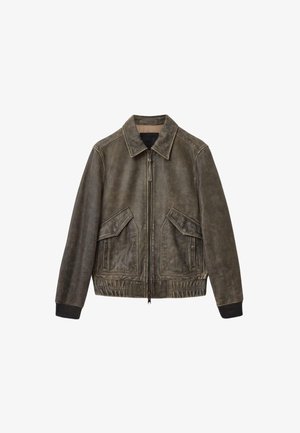 Odinė bombonešio striukė nuskaidrintos alyvuogių žalios spalvos, su užtrauktuku priekyje, didelėmis šoninėmis kišenėmis, elastinėmis rankogaliais ir klasikinio dizaino apykakle.