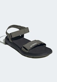 Mørk grå sandaler med justerbare stoffstropper og en teksturert svart gummisåle. Har en fremtredende TERREX-logo på stroppen.