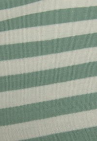 Zeleno-krémová pruhovaná tkanina s ribovanou strukturou. Pruhy jsou rovnoměrně rozložené a předvádějí jemnou pleteninu.