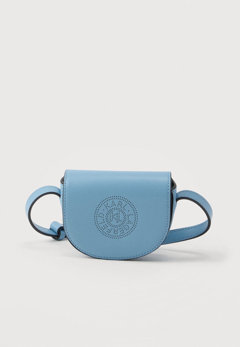 Μικρή γαλάζια δερμάτινη τσάντα χιαστί με στρογγυλό διάτρητο λογότυπο στο μπροστινό μέρος και ρυθμιζόμενο ιμάντα σε λευκό φόντο.