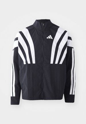 Giacca nera con colletto alto, zip completa e audaci strisce diagonali bianche sulle maniche. Realizzata in tessuto leggero con una texture morbida.