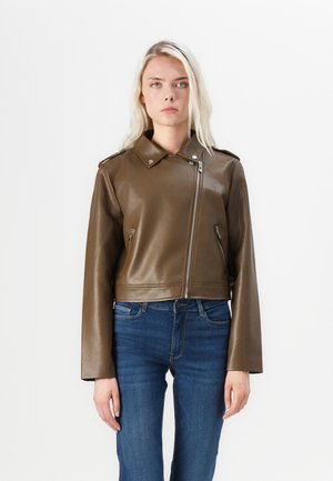 Brun kunstlær cropped jakke med glidelås, spiss krage og lange ermer, kombinert med blå denimjeans.