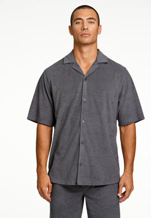 Chemise gris à manches courtes avec boutons, en texture douce, dotée d'un col, avec des boutons violets et une coupe légèrement ample.