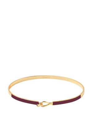 Bracelet en or avec une finition lisse, mettant en avant un accent bourgogne profond et un détail de fermeture unique. Le design mince et circulaire renforce l'élégance.