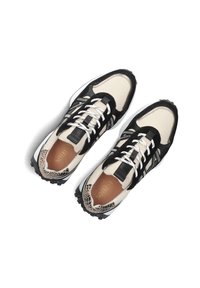 Zwarte en beige sneakers van mesh en suede, met een gestreept accent, een dikke zwarte zool en witte veters.