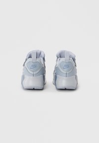 Nike superge v svetlo modri barvi s teksturiranim mrežastim zgornjim delom, gumijastim petnim delom in dvema zankama na hrbtni strani za enostavno obuvanje.